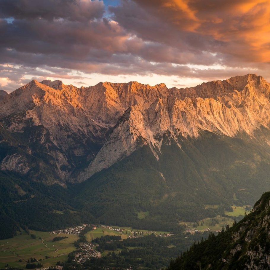 Berglandschaft mit dramatischem Licht und Wolken über den Gipfeln zur goldenen Stunde.